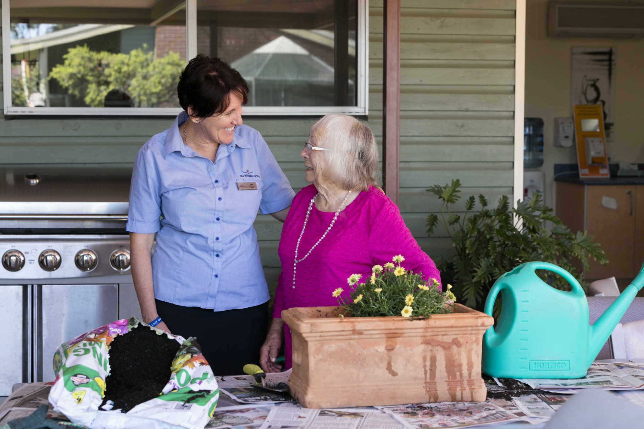 A Whiddon carer with a resident doing some gardening as part of a Whiddon creative ageing program.