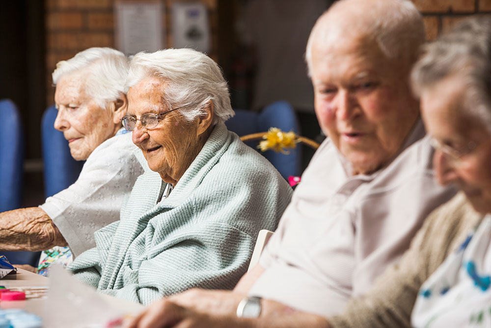 A group of residents chatting and having a great time at one of Whiddon's aged care homes.