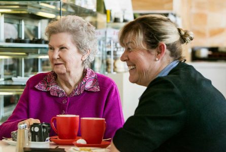 A Whiddon carer and resident from Whiddon's nursing home in Bathurst seen enjoying coffee together at a social outing.