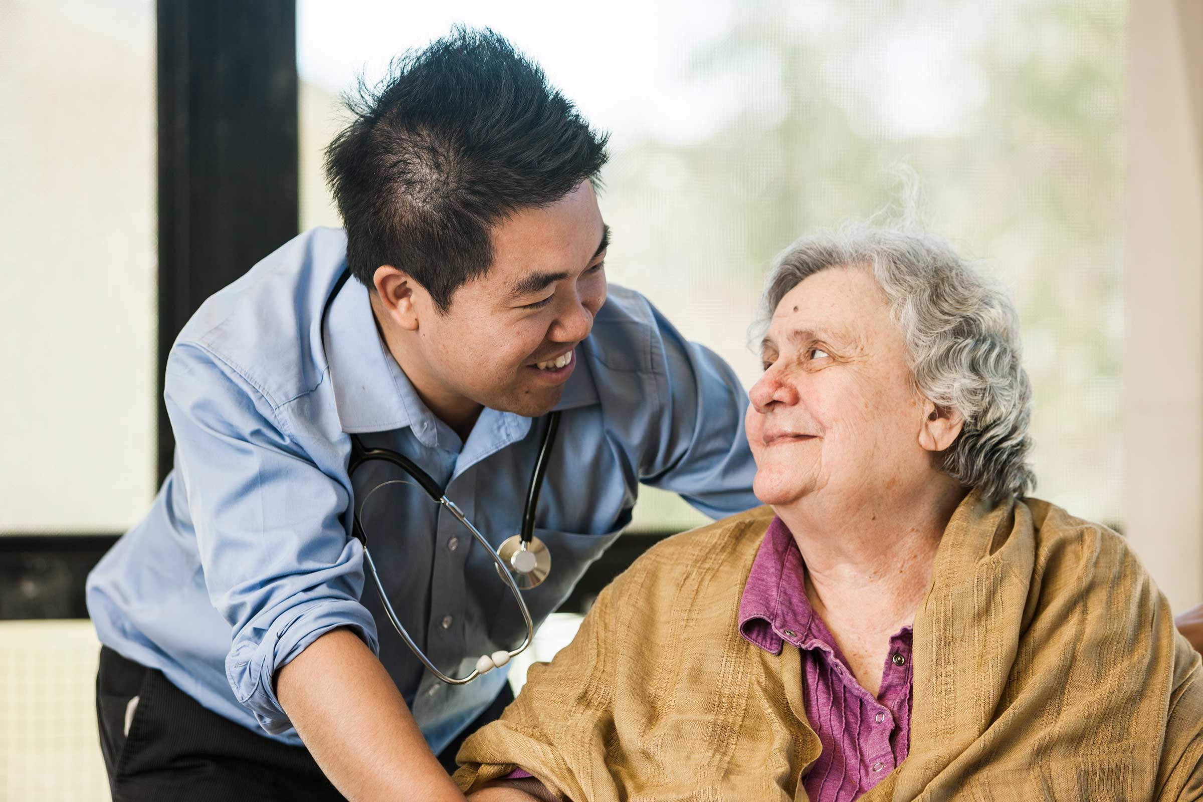 A carer smiling with a resident at Whiddon Narrabri.