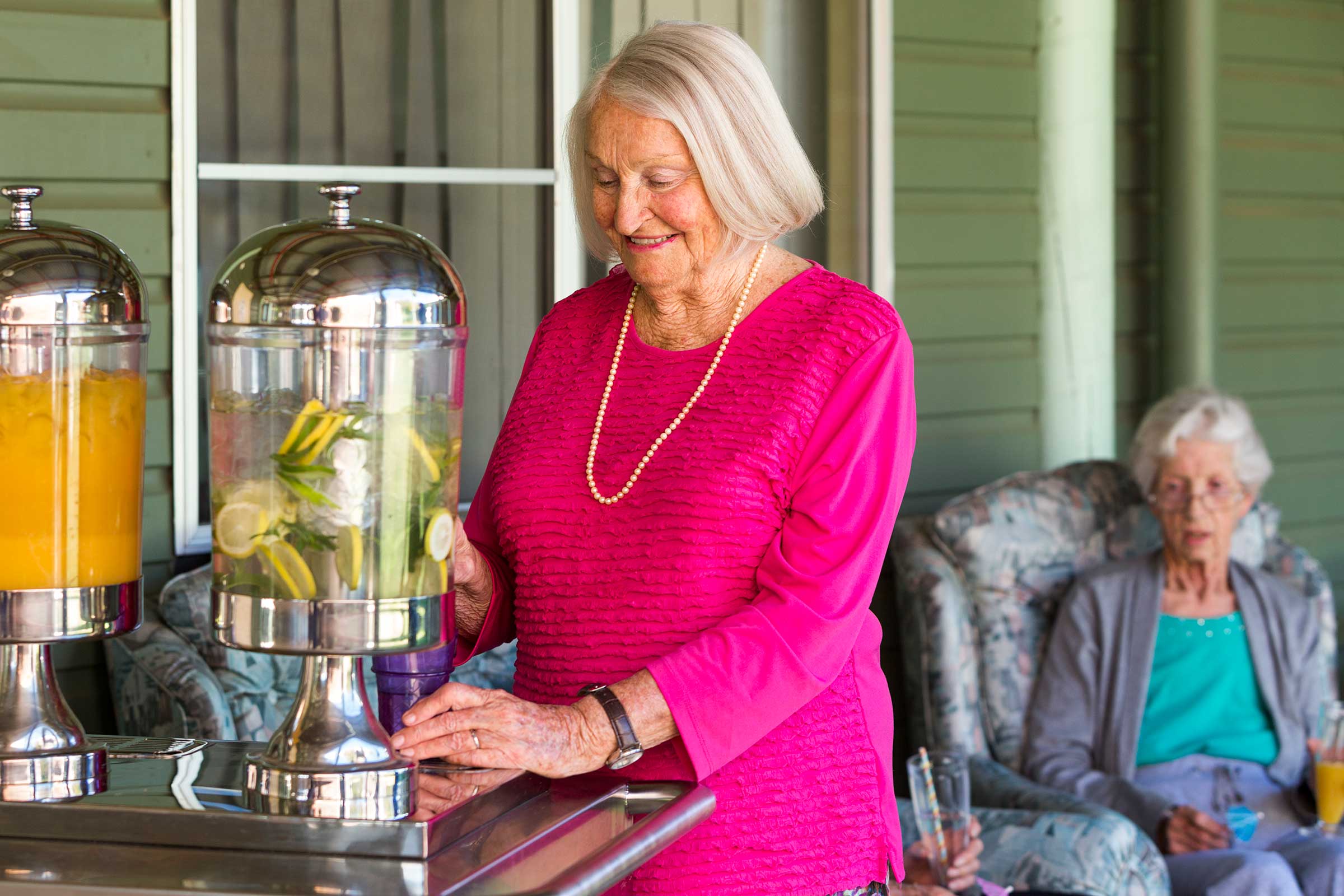 A resident enjoying some refreshing iced lemon water with other residents at Whiddon Narrabri.